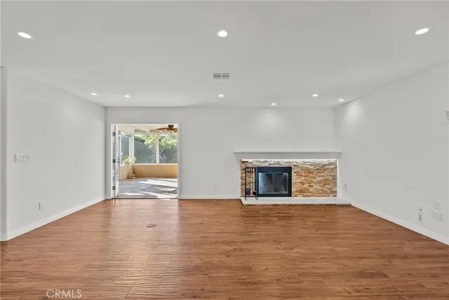 a view of an empty room with a fireplace and a window