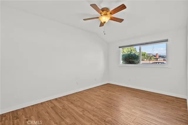 an empty room with a window and a ceiling fan