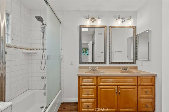 a bathroom with a sink vanity granite tub and shower