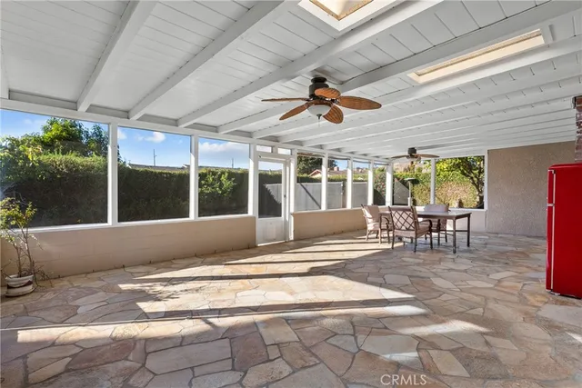 a view of a patio with table and chairs potted plants with floor to ceiling window