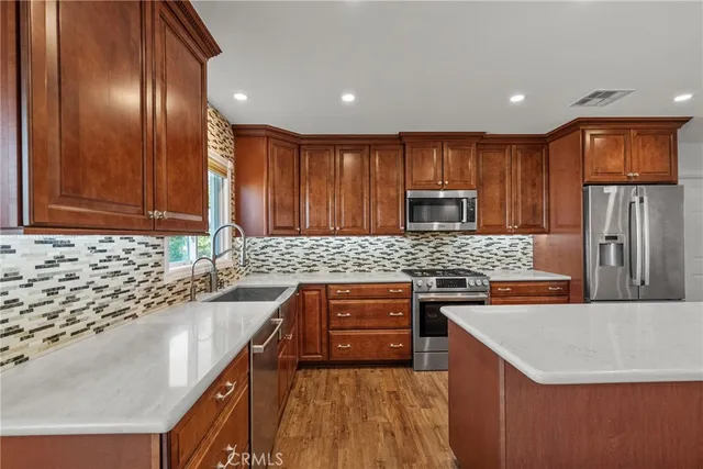 a kitchen with stainless steel appliances granite countertop a sink stove microwave and refrigerator