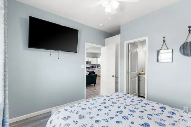 a bedroom with a bed next to a window with wooden floor