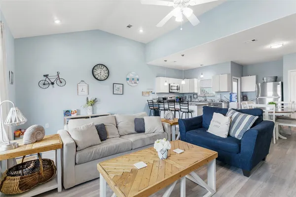 a living room with furniture kitchen view and a chandelier