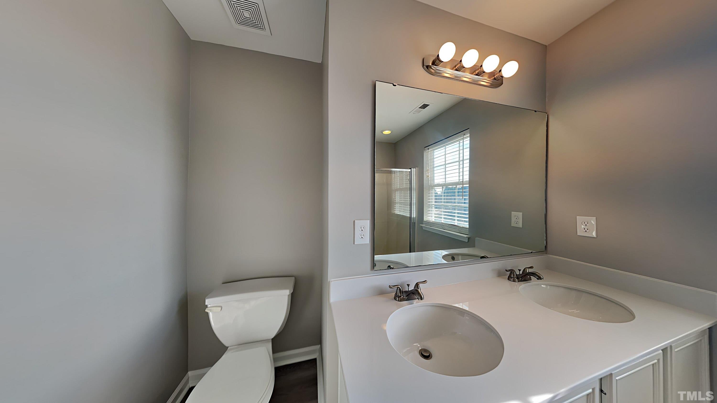 4105 Springfield Creek Drive Raleigh, NC 27616 - Photo 8 of 12 a bathroom with a toilet sink and mirror