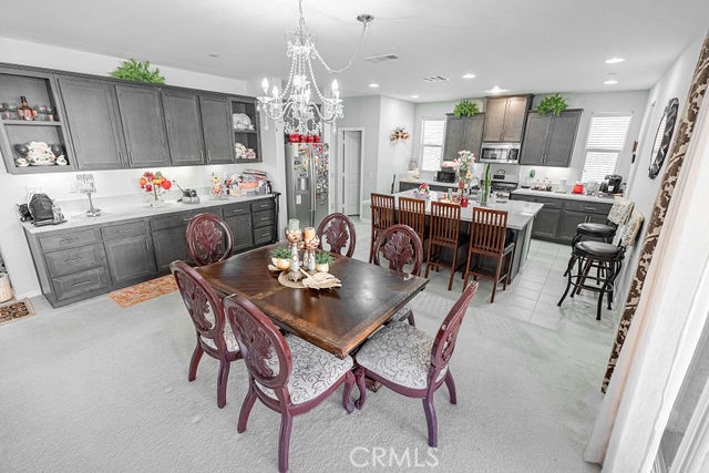 39580 Strada Pozzo Lake Elsinore, CA 92532 - Photo 18 of 67 a dining room filled chandelier and a dining table with kitchen view
