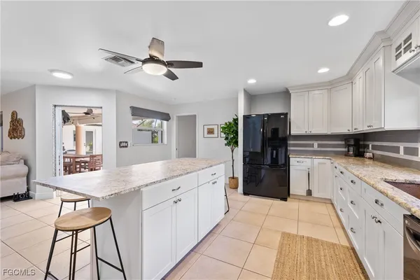a kitchen with granite countertop white cabinets and stainless steel appliances