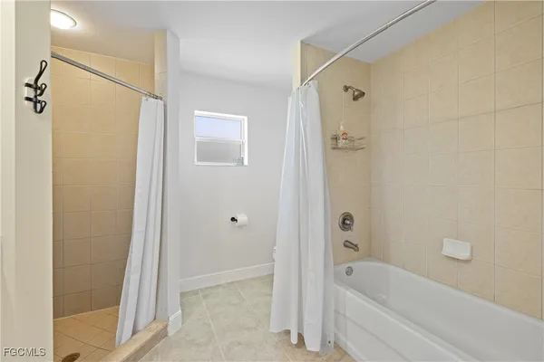 a bathroom with a granite countertop sink a mirror and a bathtub