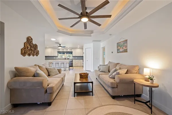 a living room with furniture flowerpot and a chandelier