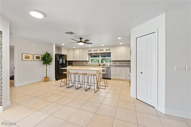 a kitchen with stainless steel appliances kitchen island granite countertop a refrigerator a stove a sink a dining table and chairs