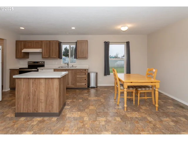 a open kitchen with kitchen island granite countertop a sink counter top space and cabinets