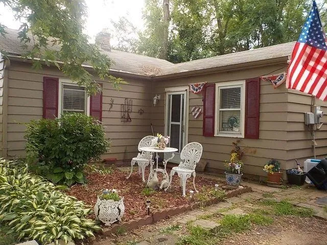 a view of a chair and table in backyard of the house