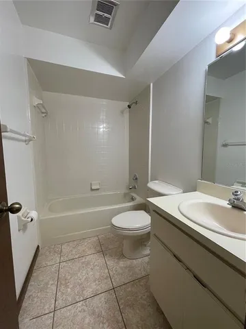 a bathroom with a granite countertop sink a toilet and shower