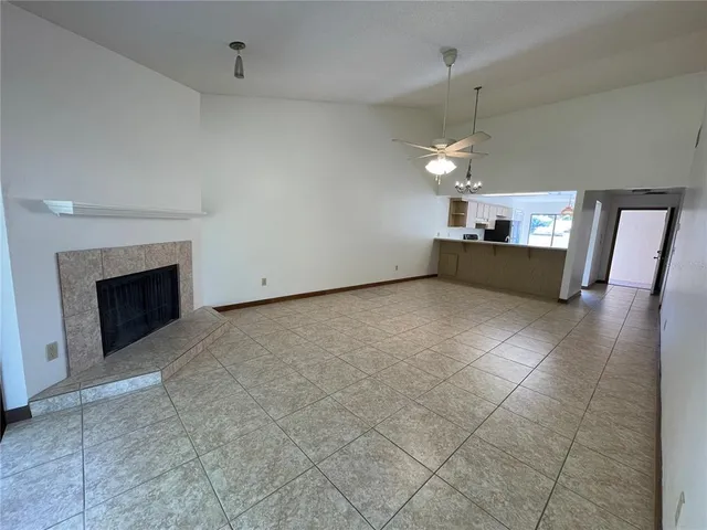 an empty room with windows and fireplace