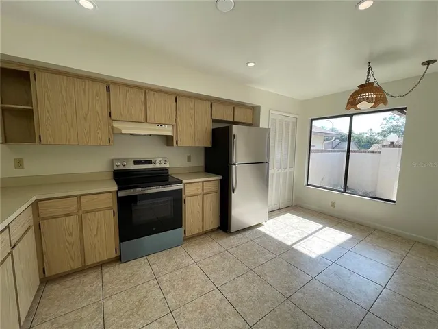 a kitchen with a refrigerator a stove a sink and cabinets
