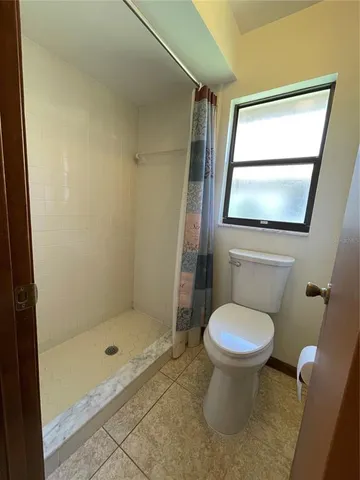a bathroom with a toilet and a shower