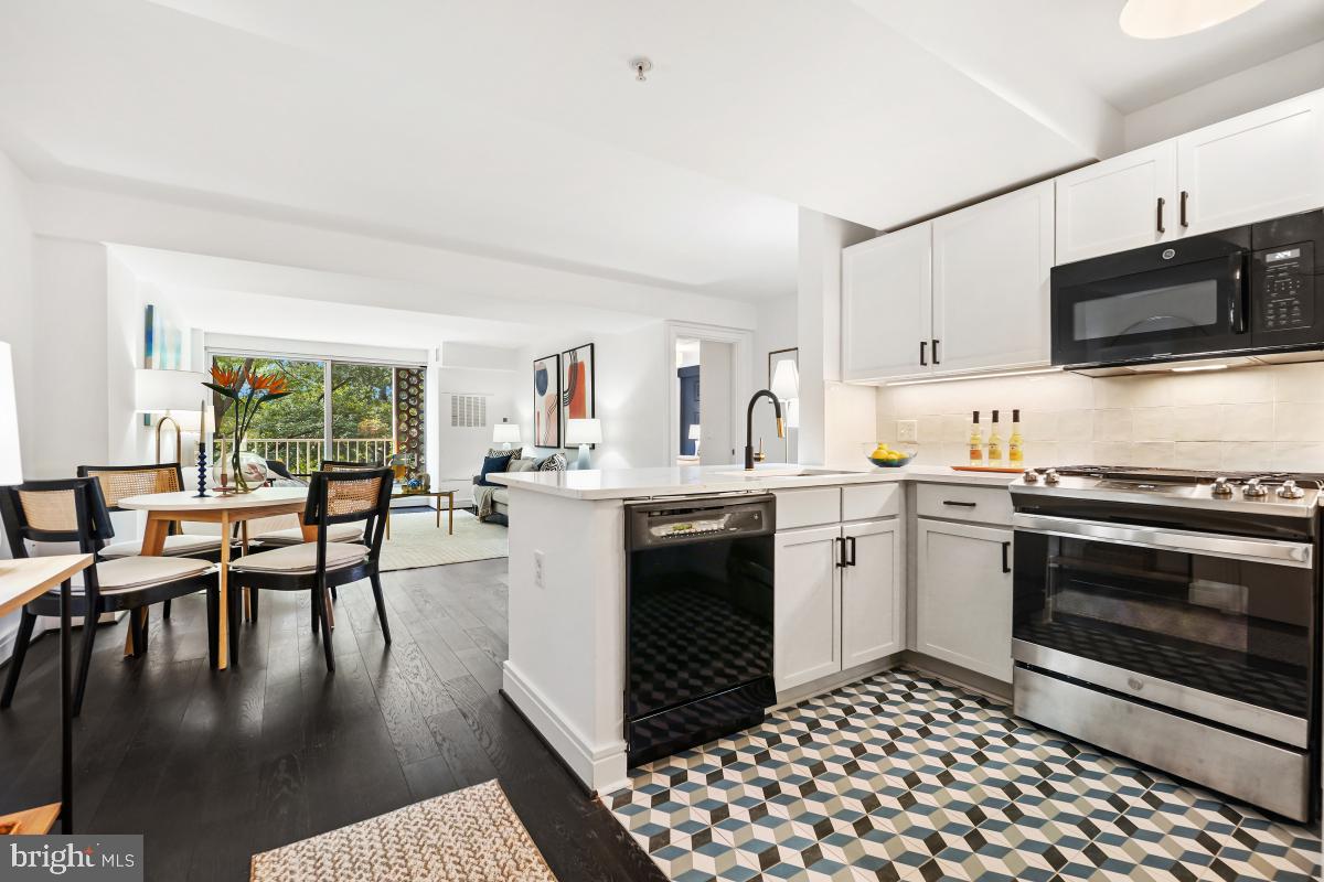 800 4th Street Southwest, Unit N301 Washington, DC 20024 - Photo 4 of 31 a kitchen with stainless steel appliances granite countertop a stove top oven a sink a dining table and chairs with wooden floor