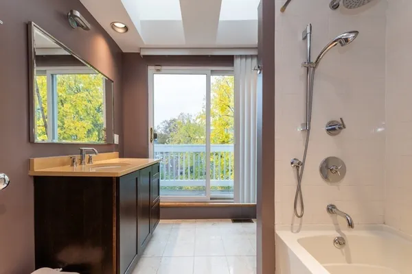 a bathroom with a sink a bathtub and next to a window