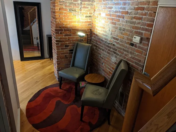 a view of a room with furniture and wooden floor