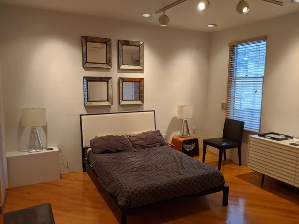 a bedroom with a bed and wooden floor