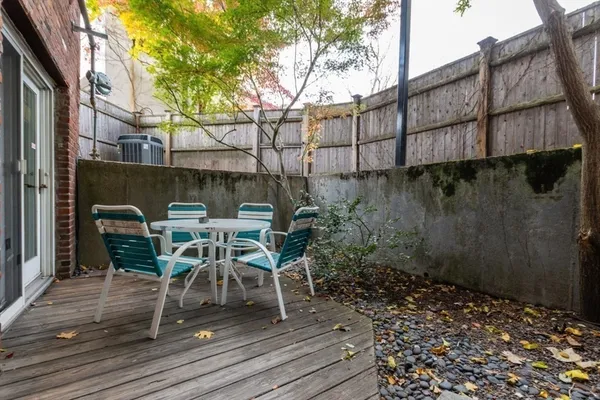 a view of a patio with table and chairs and wooden floor