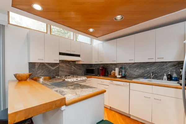 a kitchen with stainless steel appliances granite countertop a sink a stove and a refrigerator