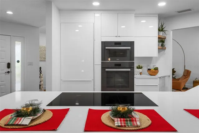 a kitchen with stainless steel appliances kitchen island granite countertop a refrigerator and a stove