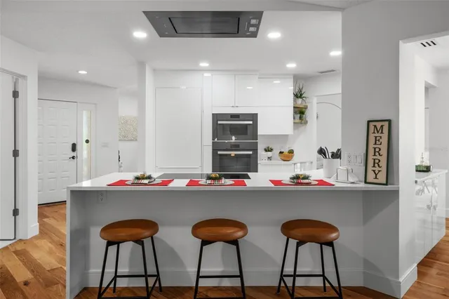 a kitchen with stainless steel appliances kitchen island a table and chairs in it