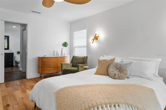 a bedroom with a bed and wooden floor