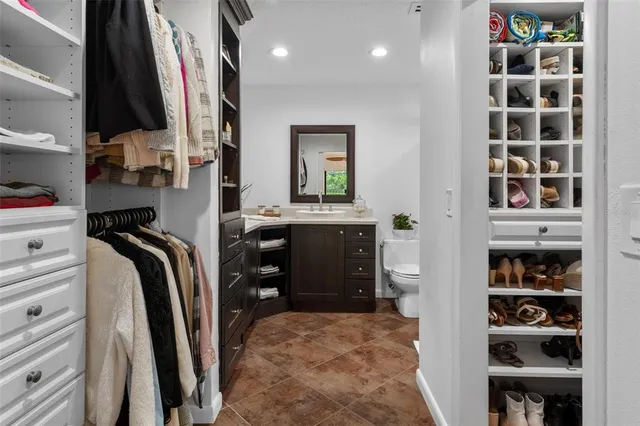 a view of walk in closet with clothes and shoes