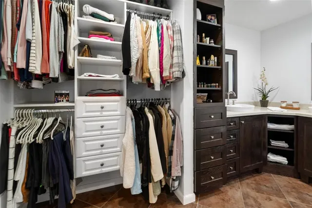 a view of walk in closet with clothes and shoes
