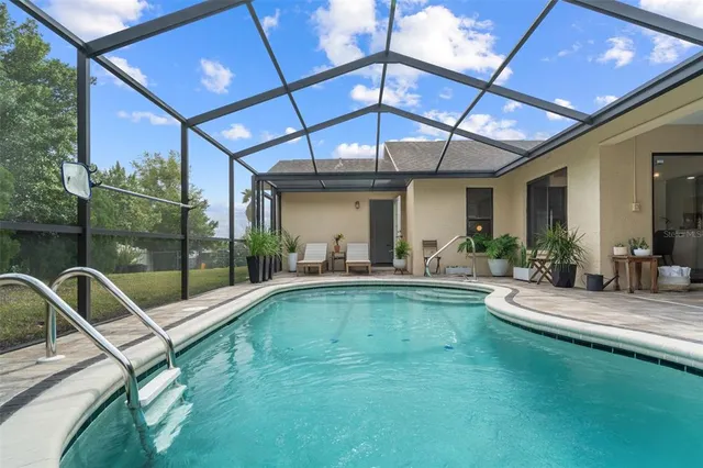 a view of a backyard with a patio and swimming pool