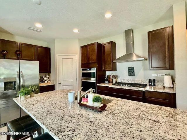 a kitchen with granite countertop kitchen island cabinets and refrigerator