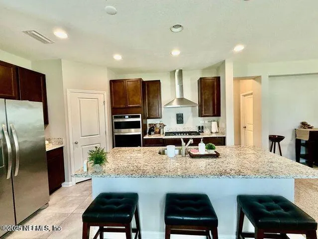 a living room with kitchen view and a flat screen tv