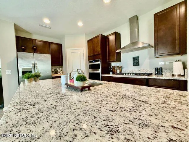 a kitchen with stainless steel appliances granite countertop a sink stove and refrigerator