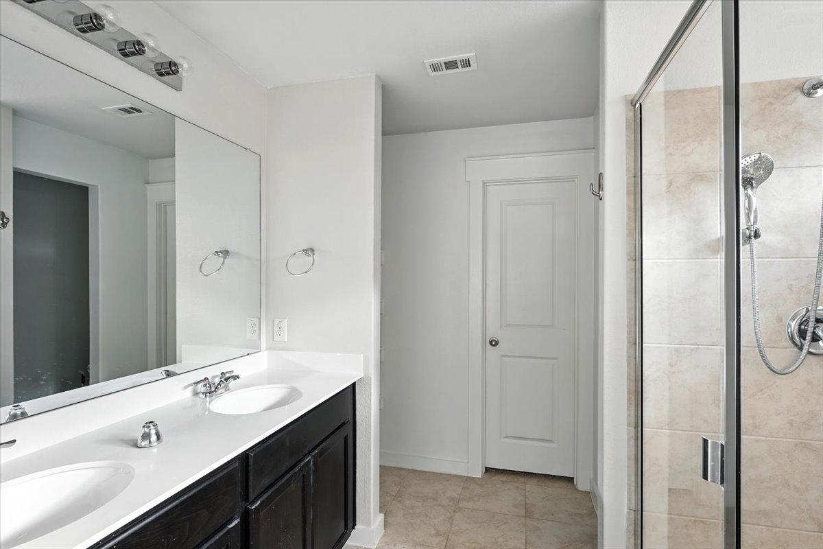 305 Old Trinity Way Georgetown, TX 78628 - Photo 13 of 20 a bathroom with a double vanity sink mirror and shower