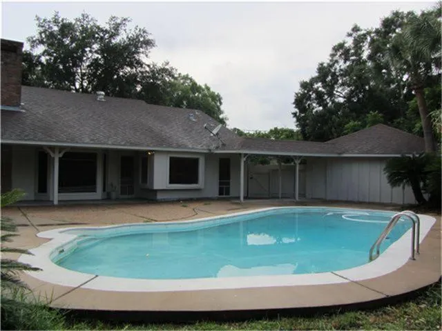a view of a house with pool and a yard