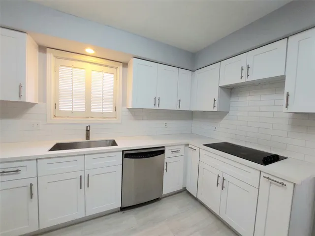 a kitchen with white cabinets white appliances and sink