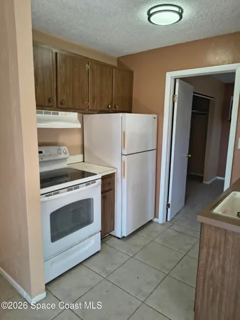 a white refrigerator freezer and a stove sitting inside of a kitchen