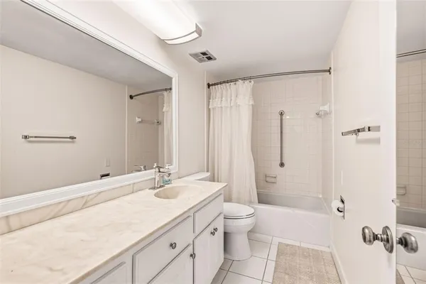 a bathroom with a granite countertop sink a toilet a mirror and shower
