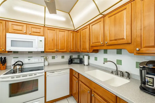a kitchen with stainless steel appliances granite countertop a sink a stove and cabinets