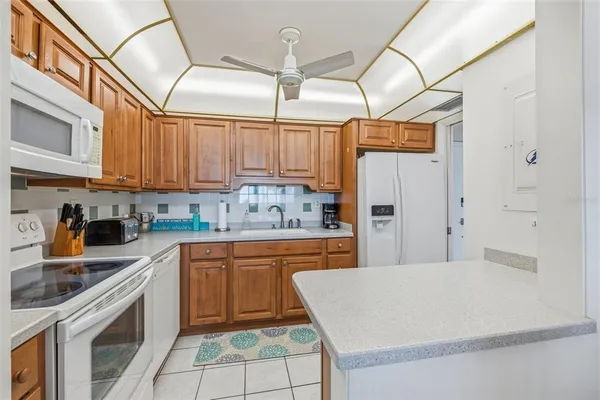 a kitchen with stainless steel appliances granite countertop a refrigerator and wooden cabinets