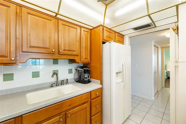 a kitchen with a sink a refrigerator and cabinets