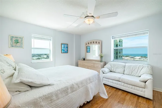 a bedroom with a large bed couch and window