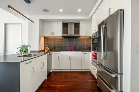a kitchen with white cabinets and appliances