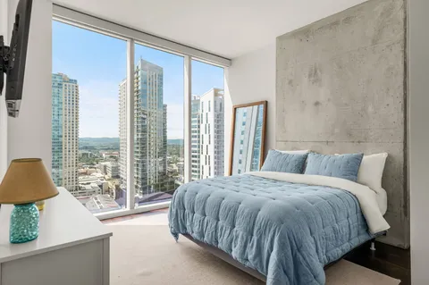 a large bedroom with a large bed and flat tv screen on the dresser