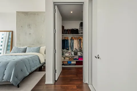 a view of walk in closet with clothes and shoes