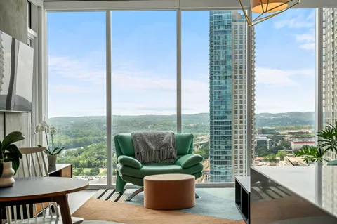 a living room with furniture and a floor to ceiling window