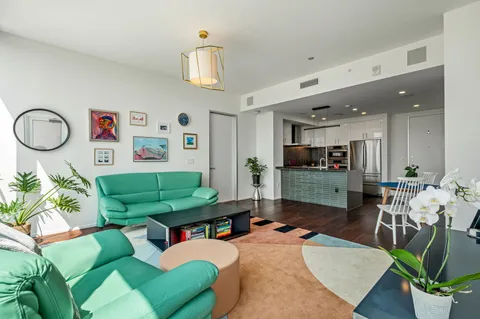 a living room with furniture kitchen view and a large window