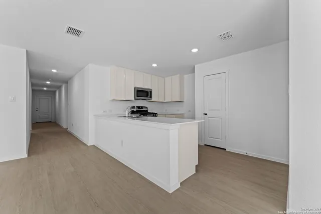 a kitchen with granite countertop white cabinets and stainless steel appliances