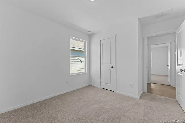 an empty room with windows and closet